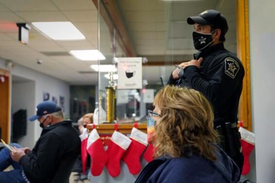 A police officer stands outside the school board meeting of Community High School District 99, in Downers Grove, Ill., on Dec. 13, 2021. (Cara Ding/The Epoch Times)
