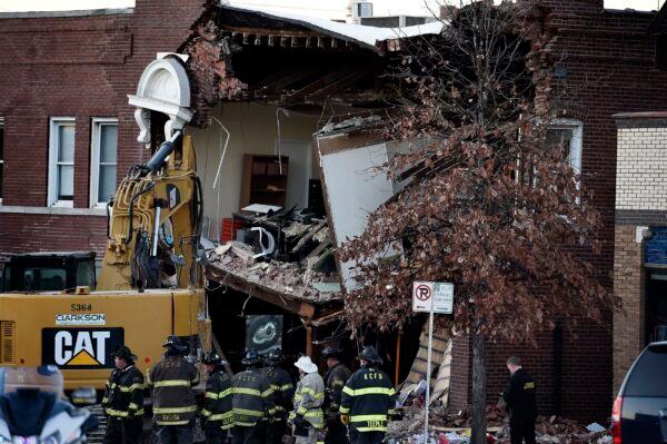 Crews were still on the scene early Thursday, Dec. 16, 2021, after a firetruck collided with a car and caused a building collapse Wednesday night in Kansas City, Mo. (Rich Sugg /The Kansas City Star via AP)