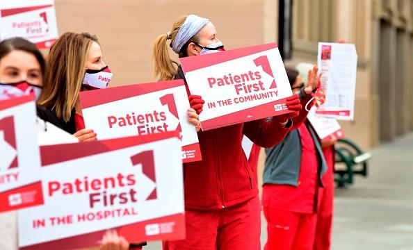 Nurses from the Keck Hospital of USC (Universtity of Southern California) hold placards during a nationwide protest organized by the National Nurses United demanding hospitals to put patients first, during the Covid-19 pandemic in Los Angeles, California on January 27, 2021 . - (Photo by Frederic J. BROWN / AFP) (Photo by FREDERIC J. BROWN/AFP via Getty Images)