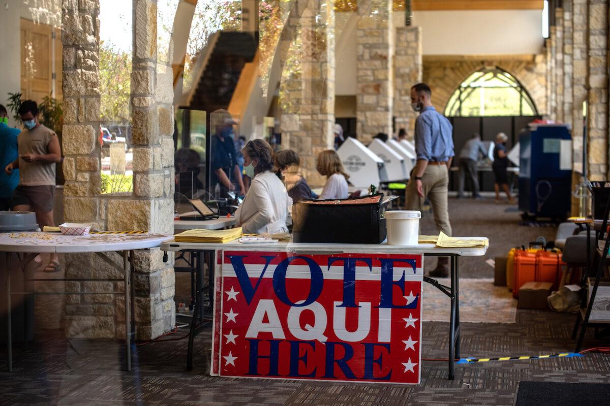 Poll workers help voters inside a polling location in Austin, Texas, Oct. 13, 2020. (Sergio Flores/Getty Images)