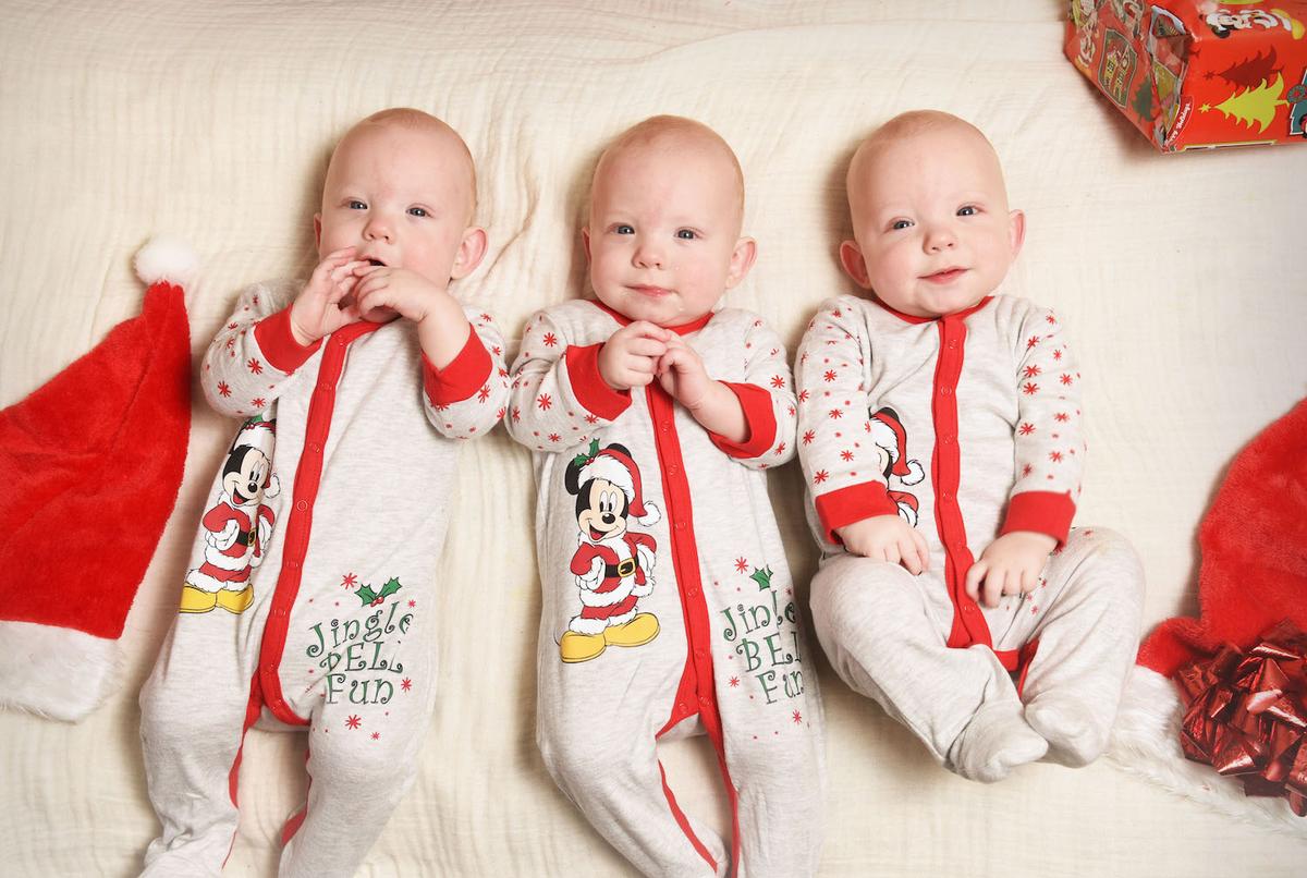 The triplets, Colby, Odyn, and Rico, are in their Christmas onesies. (Courtesy of Caters News)