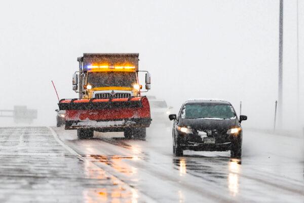 A snowplow drops salt on the road near Denver International Airport on March 13, 2021. (Michael Ciaglo/Getty Images)
