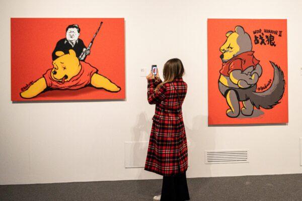 A visitor takes photos of "Winnie the Trophies, 2017", an artwork by Chinese dissident artist Badiucao at the exhibition "China is (not) near -- works of a dissident artist", at the Santa Giulia museum in Brescia, Italy on Nov. 12, 2021. (Piero Cruciatti/AFP via Getty Images)