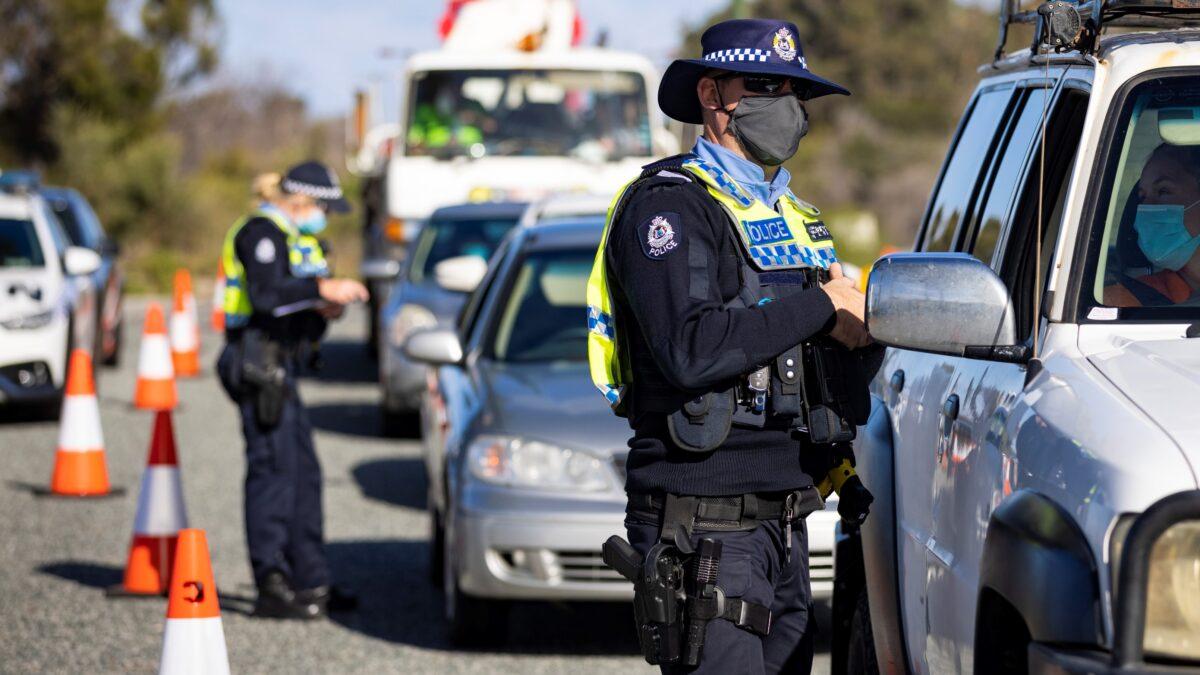 A member of WA Police inspects cars at a border checkpoint on Indian Ocean Drive in Perth, Australia, on Jun. 29, 2021. (Matt Jelonek/Getty Images)