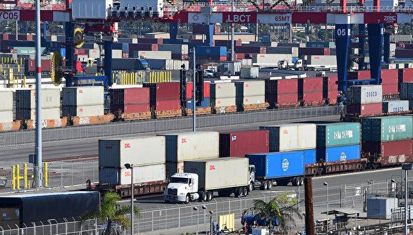 A container truck makes its way past a row of containers stacked in two's at the Port of Long Beach, California on Nov. 12, 2021. (Frederic J. Brown/AFP)