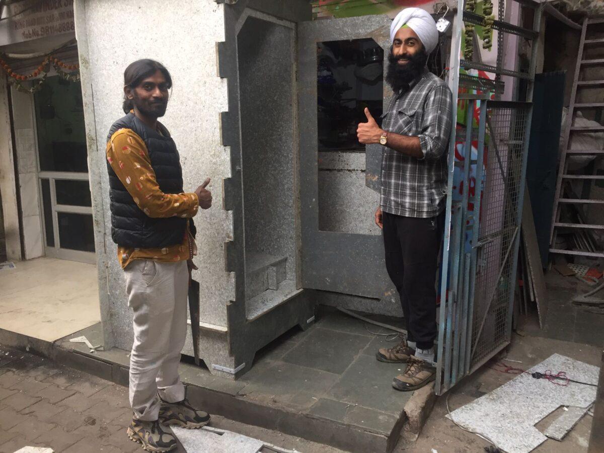 Ashwini Agarwal (L) and Sahaj Umang Singh of Basic SHIT organization outside their new dry toilet prototype in Narojini in New Delhi on November 30, 2021. This toilet is built using recycled plastic equivalent to preventing over one tonne of carbon emissions into the environment (Venus Upadhayaya/Epoch Times)