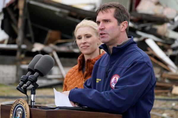Kentucky Gov. Andy Beshear, standing next to his wife Britainy Beshear, speaks after surveying storm damage from tornadoes and extreme weather in Dawson Springs, Ky., on Dec. 15, 2021. (Andrew Harnik/AP Photo)