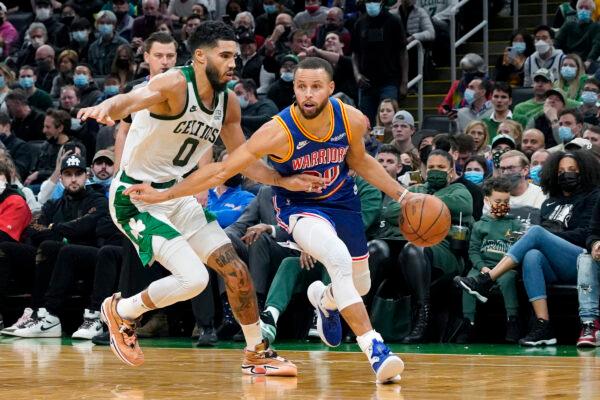 Golden State Warriors guard Stephen Curry (30) drives against Boston Celtics forward Jayson Tatum (0) during the second half of an NBA basketball game, in Boston, on Dec. 17, 2021. (Mary Schwalm/AP Photo)