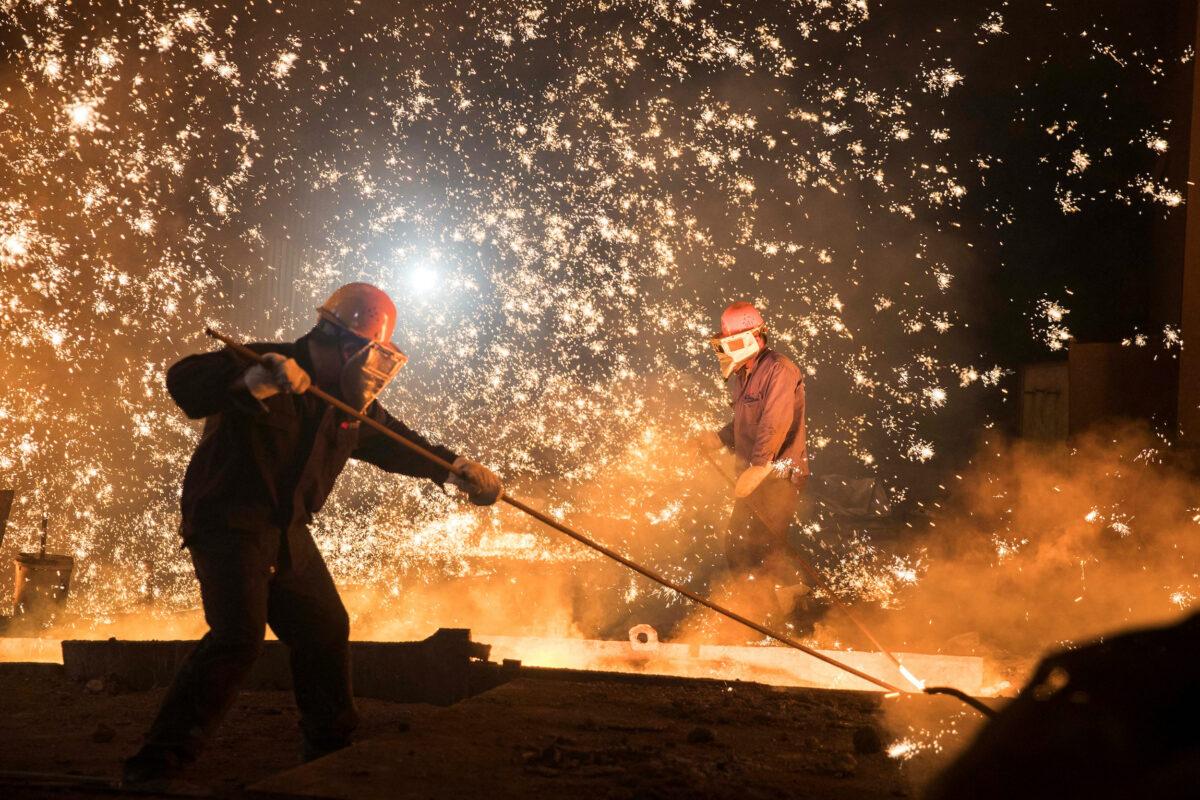Laborers work at a steel plant of Shandong Iron & Steel Group in Jinan, Shandong Province, China, on July 7, 2017. (Stringer/Reuters)