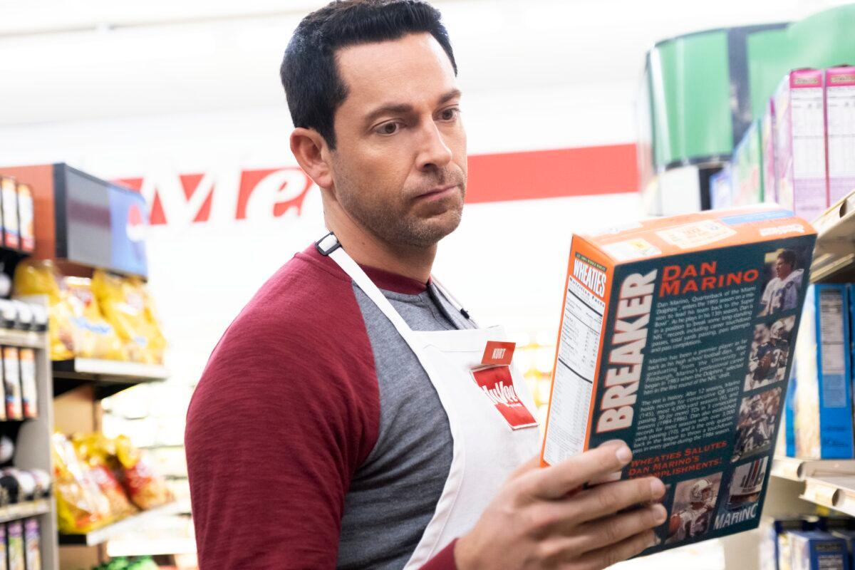 Kurt Warner (Zachary Levi) stocks shelves and gets depressed seeing Dolphins quarterback Dan Marino's face on a Wheaties box, in "American Underdog." (Lionsgate)