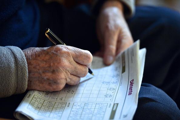 Crossword puzzles, soduku, trivia quizzes, or even learning a new skill or language can keep your brain exercised and can slow memory loss. - By GEORGES GOBET/AFP via Getty Images