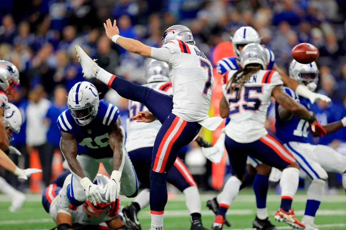 Indianapolis Colts' Matthew Adams (R) blocks a punt by New England Patriots punter Jake Bailey (7) during the first half of an NFL football game. The Colts’ E.J. Speed ran the ball back for a touchdown, in Indianapolis, on Dec. 18, 2021. (Aaron Doster/AP Photo)