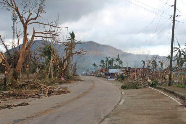 Toppled trees lie along an empty road in Surigao del Norte province, southern Philippines, on Dec. 18, 2021. (Philippine Coast Guard via AP)