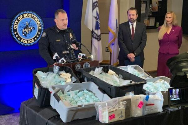 L-R: Scottsdale Police Chief Jeff Walther in front of a display of illicit fentanyl-laced pills and other narcotics; Arizona Attorney General Mark Brnovich, and Cheri Oz, special agent in charge of the DEA’s Phoenix field division at a press conference in Scottsdale, Ariz., on Dec. 16, 2021. (Scottsdale PD)