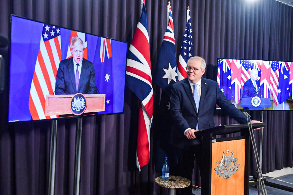 Britain’s Prime Minister Boris Johnson (left screen), Australia’s Prime Minister Scott Morrison (C), and U.S. President Joe Biden (right screen) at a joint press conference via AVL from The Blue Room at Parliament, in Canberra, Australia, on Sept. 16, 2021. (Mick Tsikas/AAP Image)
