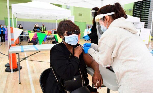  An employee of the Los Angeles Unified School District (LAUSD) receives her COVID-19 vaccination at a site opened by the LAUSD for its employees in Los Angeles, Calif., on Feb. 17, 2021. (Frederic J. Brown/AFP via Getty Images)