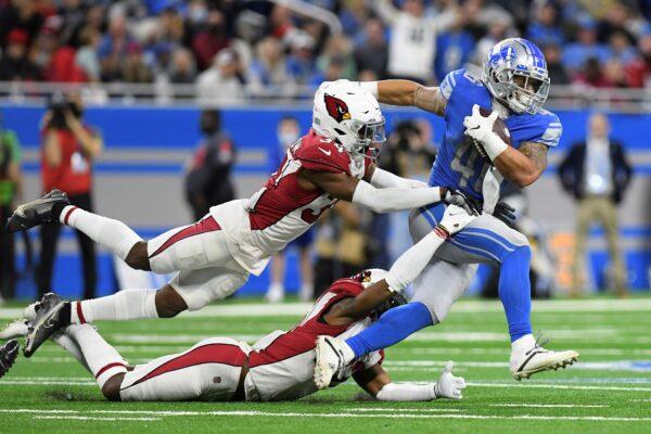 Detroit Lions running back Craig Reynolds is caught by Arizona Cardinals free safeties Jalen Thompson, top, and Deionte Thompson (22) during the second half of an NFL football game in Detroit, on Dec. 19, 2021. (Lon Horwedel/ AP Photo)