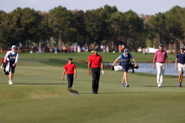 Tiger Woods and his son Charlie Woods walk up the 18th fairway during the second round of the PNC Championship golf tournament in Orlando, Fla., on Dec. 19, 2021. (Scott Audette/AP Photo)