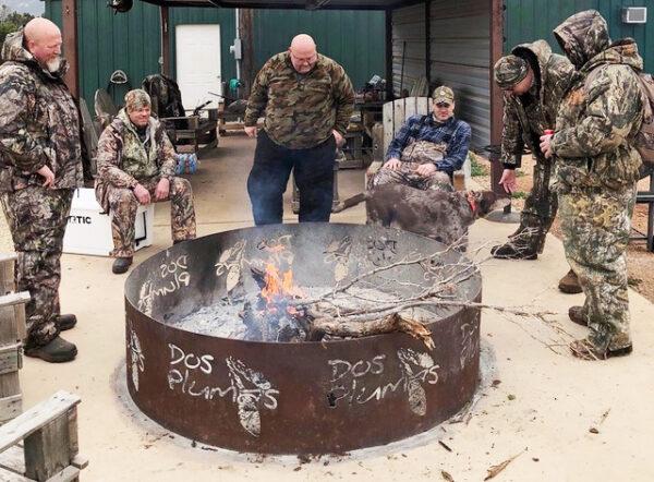 Hunters relax around a fire in late 2021 at Allen Williams's Dos Plumas Hunting Ranch in Texas. (Allen Williams/Dos Plumas)