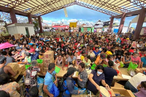 People affected by typhoon Rai gather during a distribution of relief goods, in Surigao City, Surigao del Norte, Philippines, on Dec. 20, 2021. (Erwin Mascarinas/Greenpeace/Handout via Reuters)