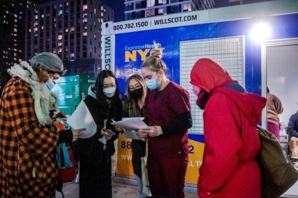 People check their rapid COVID-19 test results outside of a testing site on the Lower East Side of Manhattan in New York on Dec. 21, 2021. (Brittainy Newman/AP Photo)