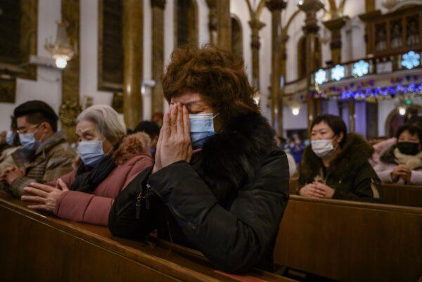 Chinese Christians pray during a Christmas Mass at a Catholic Church in Beijing on Dec. 24, 2020. (Kevin Frayer/Getty Images)