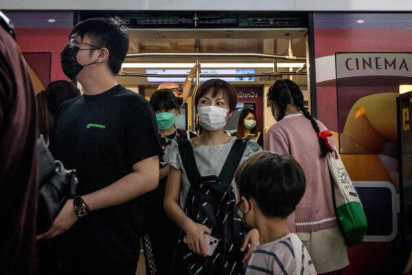 People wearing face masks exit a BTS Skytrain in Bangkok on Dec.6, 2021, as Thailand recorded its first case of the coronavirus Omicron variant which was an American businessman of Thai descent who caught the virus while overseas. (Jack Taylor/AFP)