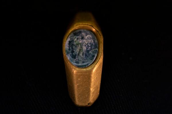 A Roman gold ring, its green gemstone carved with the figure of a shepherd carrying a sheep on his shoulders, dating to around 1,700 years ago, is displayed after it was found near the ancient city of Caesarea, in Jerusalem, on Dec. 22, 2021. (Ariel Schalit/AP Photo)