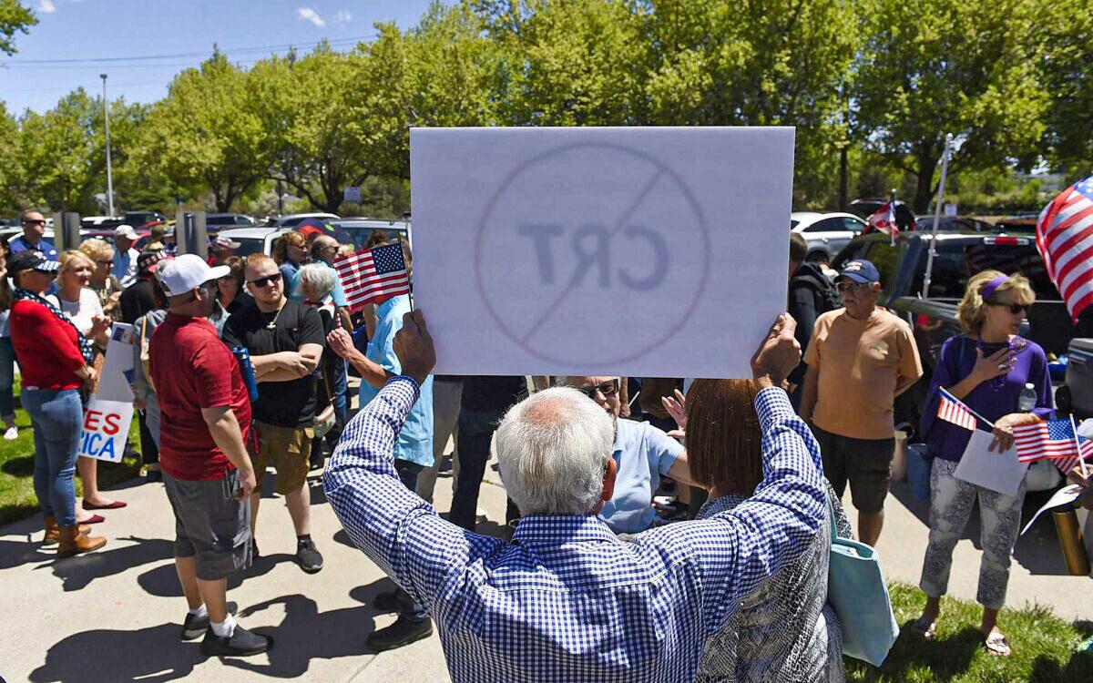 A man holds up a sign against critical race theory during a protest outside of a Washoe County School District board meeting in Reno, Nev., on May 25, 2021. (Andy Barron/Reno Gazette-Journal via AP)