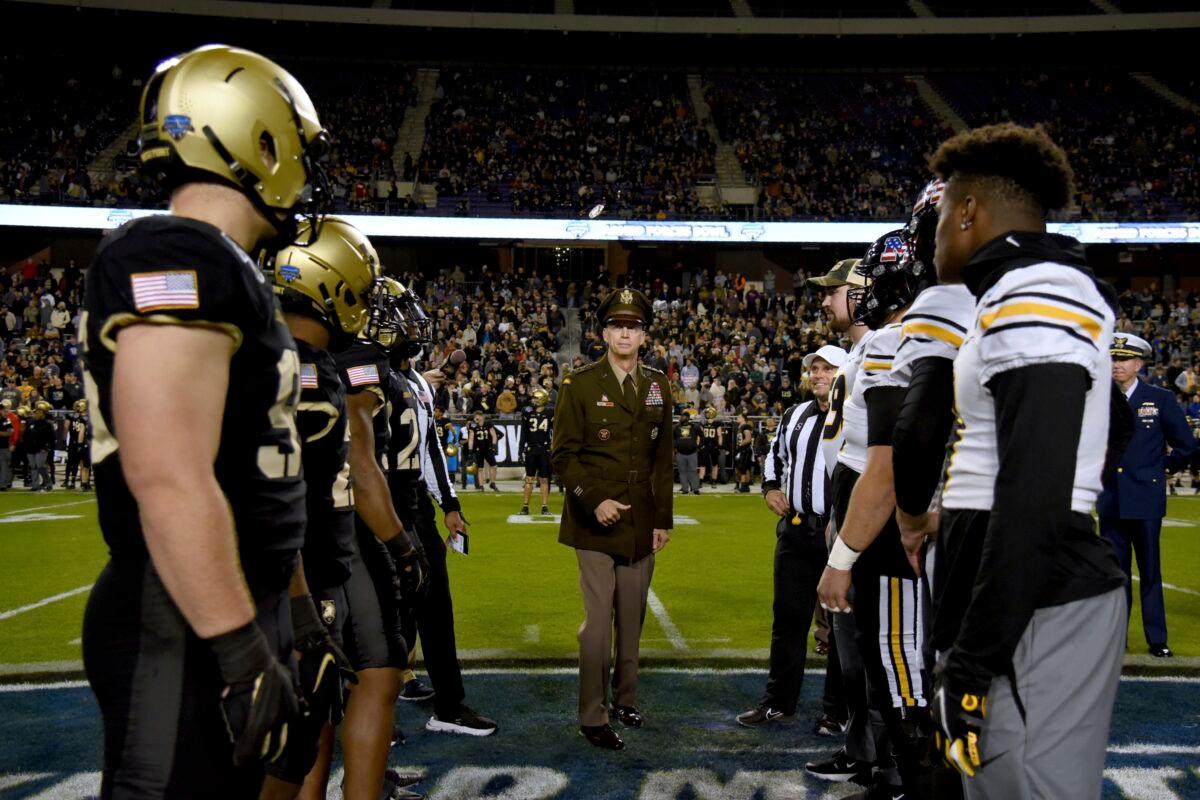 Army, left, and Missouri players, right, watch the coin flip at the start of the first half of the Armed Forces Bowl NCAA college football game in FORT WORTH, Texas, on Dec. 22, 2021. (Emil Lippe/AP Photo)