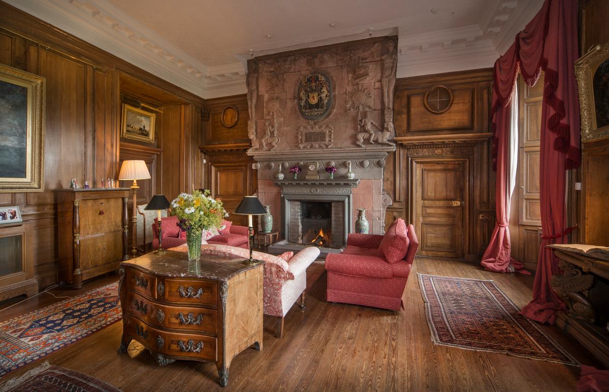 The drawing room features a famed carved fireplace set against elaborate wood paneling. This room offers wonderful open views of the surrounding parkland and is one of the key areas where guests have been entertained over the decades. (Courtesy of Itago Media Ltd.)