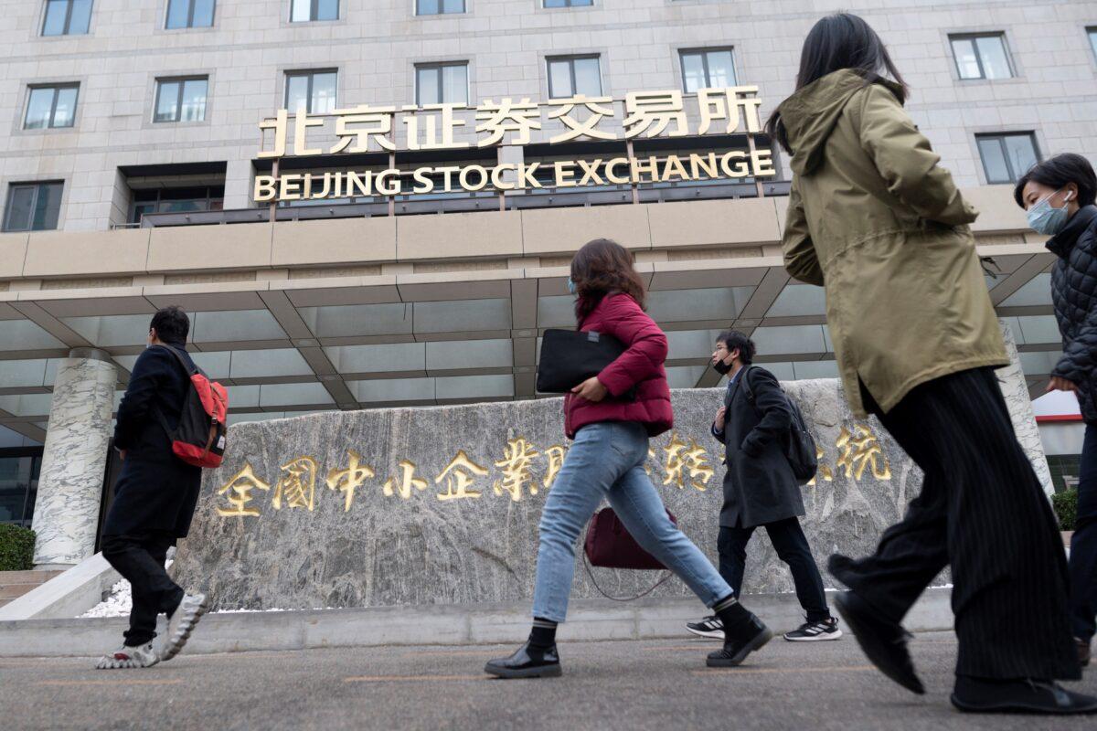 People walk past the Beijing Stock Exchange on its first day of trading in Beijing, China, on Nov. 15, 2021. (Wang Zhao/AFP via Getty Images)