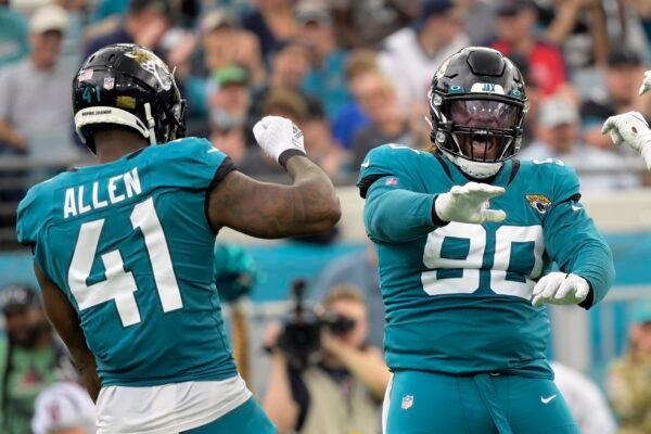Jacksonville Jaguars defensive tackle Malcom Brown (90) and outside linebacker Josh Allen (41) celebrate a play against the Houston Texans during the first half of an NFL football game, in Jacksonville, Fla., on Dec. 19, 2021. (Phelan M. Ebenhack/AP Photo/)