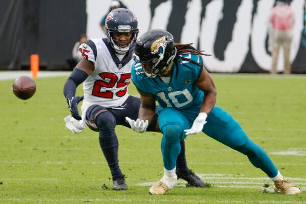 A pass slips through the hands of Jacksonville Jaguars wide receiver Laviska Shenault Jr. (10) as he is defended by Houston Texans cornerback Desmond King (25) during the second half of an NFL football game, in Jacksonville, Fla., on Dec. 19, 2021. (Stephen B. Morton/AP Photo)