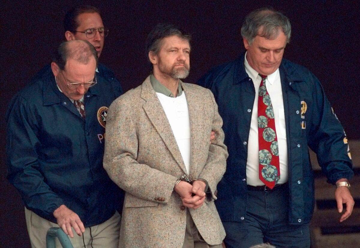 Theodore Kaczynski looks around as U.S. Marshals prepare to take him down the steps at the federal courthouse to a waiting vehicle in Helena, Mont., on June 21, 1996. (Elaine Thompson/AP Photo)