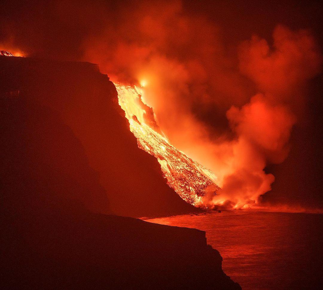 A photo depicts lava spilling into the ocean in a burst of steam. (Courtesy of <a href="https://www.instagram.com/saulsantosfotografia/">Saúl Santos Díaz</a>)