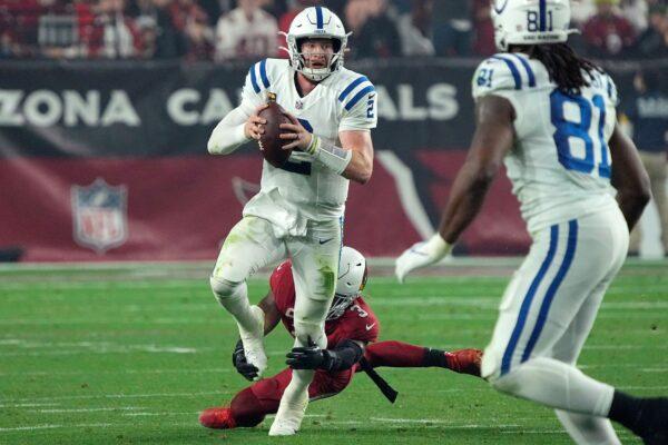 Indianapolis Colts quarterback Carson Wentz (2) is tripped up by Arizona Cardinals safety Budda Baker (3) during the second half of an NFL football game in Glendale, Ariz, on Dec. 25, 2021. (Rick Scuteri/AP Photo)