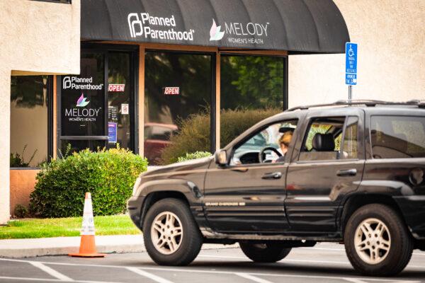 A woman waits in her car in front of a Planned Parenthood facility in Anaheim, Calif., on September 10, 2020. (John Fredricks/The Epoch Times)
