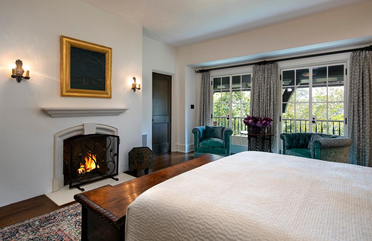 The master bedroom of the mansion has its own fireplace as well as access to a terrace overlooking the lush gardens. (Courtesy of Jim Bartsch/Jade Mills)