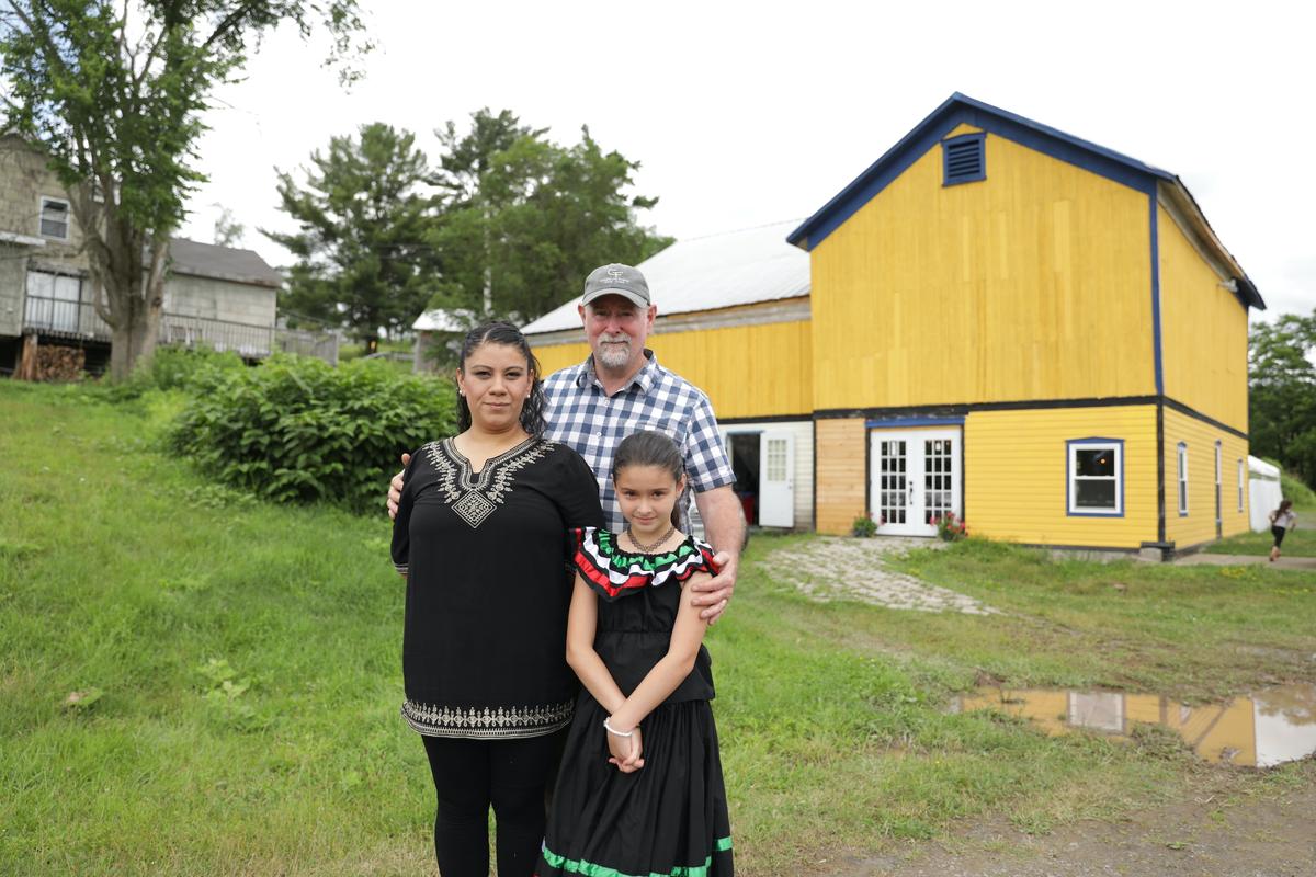 Patrick and Thanya with their daughter, Naomi, pose near the Greenane Farms restaurant. (Photo by Lux Aeterna Photography)