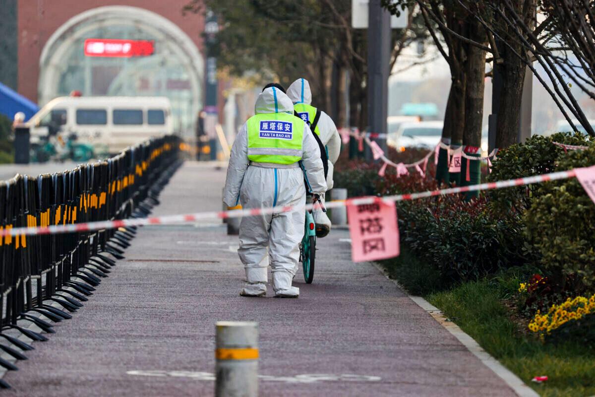 Security guards walking in an area that is under restrictions following a recent COVID-19 outbreak in Xi'an city, in Shaanxi Province, China, on Dec. 22, 2021. (STR/AFP via Getty Images)