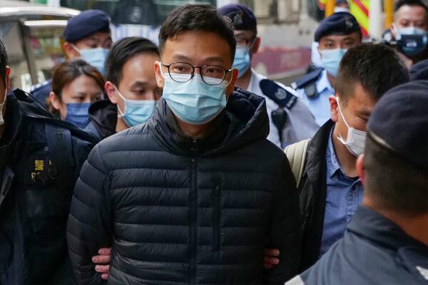 Stand News chief editor Patrick Lam is brought to the news outlet's office building in handcuffs after police were deployed to search the premises in Hong Kong's Kwun Tong district on Dec 29, 2021. (Daniel Suen/AFP via Getty Images)