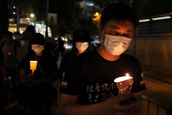 People walk with candles to mark the anniversary of the military crackdown on a pro-democracy student movement in Beijing, outside Victoria Park in Hong Kong, on June 4, 2021. (Kin Cheung/AP Photo)