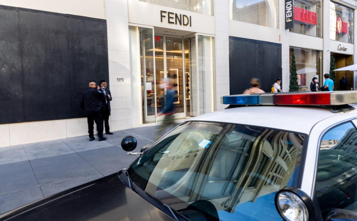 Pedestrians walk past a Fendi store with boarded up windows near Union Square in San Francisco in Nov. 30, 2021. (Ethan Swope/Getty Images)