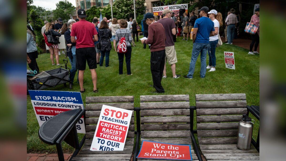 Signs are seen on a bench during a rally against "critical race theory" (CRT) being taught in schools at the Loudoun County Government Center in Leesburg, Va., on June 12, 2021. (Andrew Caballero-Reynolds/AFP via Getty Images)