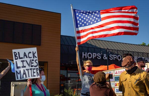 A woman waves an American flag during a Black Lives Matter protest in Yucaipa, Calif., on Aug. 1, 2020. (John Fredricks/The Epoch Times)