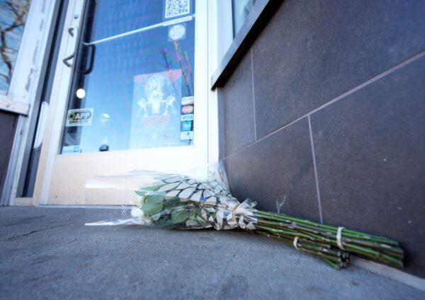 Bouquets of flowers are placed outside the door of a tattoo parlor along South Broadway in Denver, on Dec. 28, 2021. (David Zalubowski/AP Photo)