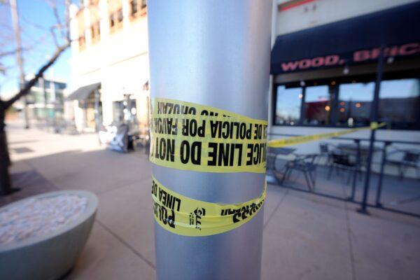 Leftover police tape is wrapped around a pole to block off the sidewalk by a pizza parlor in Denver, on Dec. 28, 2021. (David Zalubowski/AP Photo)