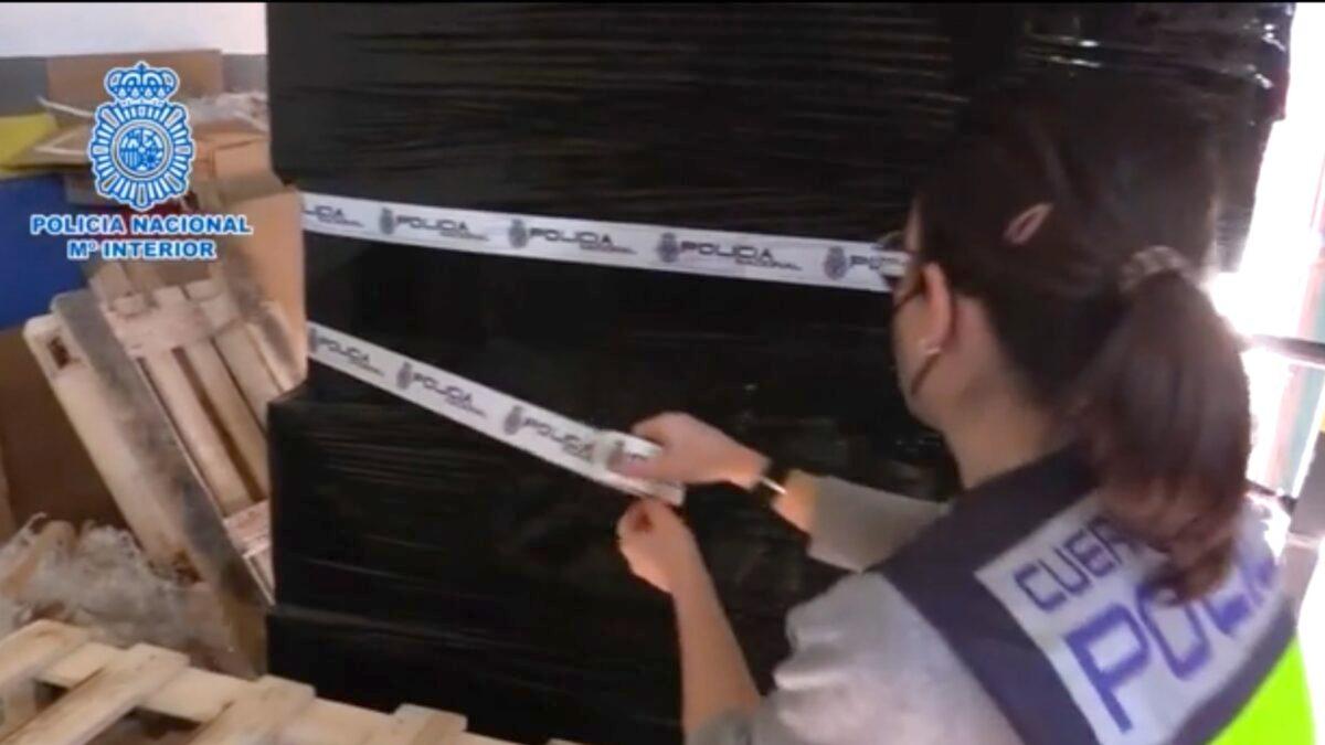 An agent from the Spanish National Police seizes a pallet with COVID-19 antigen tests after an inspection appears police to believe the tests fail to comply with specific protocols set by the government. (Courtesy of Spanish National Police)