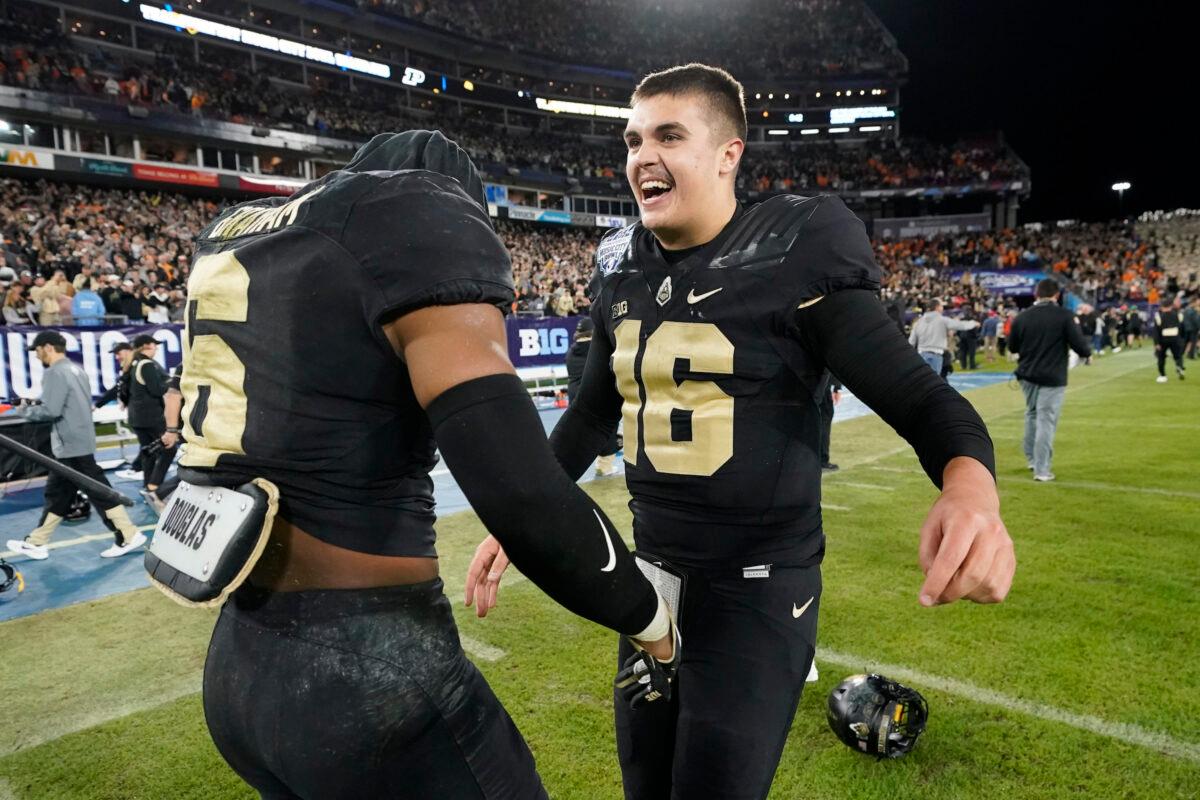 Purdue quarterback Aidan O'Connell (16) celebrates with linebacker Jalen Graham (6) after Purdue beat Tennessee in overtime in the Music City Bowl NCAA college football game, in Nashville, on Dec. 30, 2021. (Mark Humphrey/AP Photo)